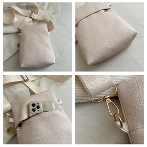 Detail view of cream lychee texture crossbody bag with zipper pocket and wide strap