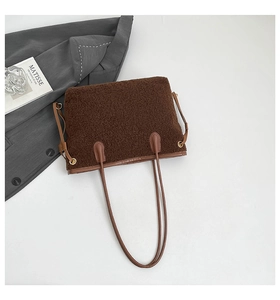 Détail du sac cabas en peau lainée avec bordure en cuir marron et œillets dorés