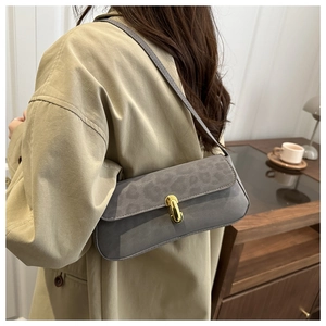 Detail of grey leopard print baguette bag with gold metal buckle and thin shoulder strap