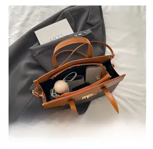Interior view of large tote bag showing phone, umbrella and vintage brown pattern details