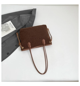 Détail d'un sac cabas en polaire marron foncé avec poignées en cuir et texture douce