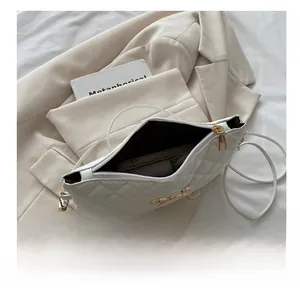 Détails de l'intérieur du sac bandoulière blanc matelassé avec nœud doré et fermeture