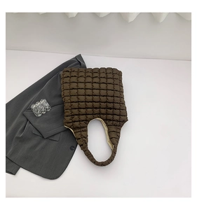 Close-up of brown quilted puffer tote bag with square stitching and spacious interior
