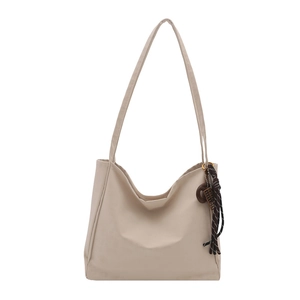 Minimalist beige oversized shoulder tote bag with vintage bead pendant detail and round shape