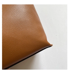 Detail of high-quality brown lychee grain leather corner with precise stitching on a tote