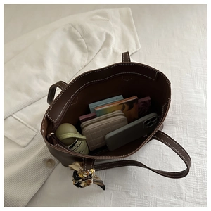 Macro shot of large capacity brown tote bag interior with scarf detail and daily items