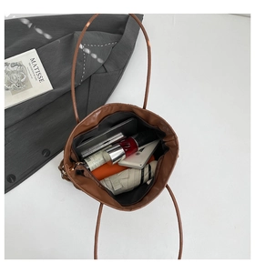 Vue de dessus détaillée de l'intérieur spacieux de ce sac fourre-tout marron avec accessoires