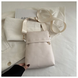 Close-up of beige lychee-patterned phone bag with adjustable nylon strap and gold hardware