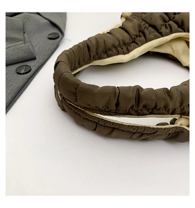 Detail of dark brown quilted bubble tote with contrasting beige lining and soft texture