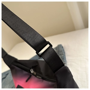 Détail de la sangle réglable en nylon noir et du tissu dégradé du sac à bandoulière
