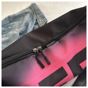 Détail du sac bandoulière dégradé noir et rose avec double fermeture éclair et logo