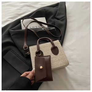 Close-up of woven tote bag with dark brown leather handles and matching coin purse