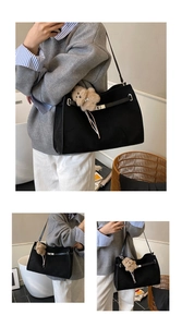 Detail of black tote bag featuring metallic turn-lock and brown plush bear charm accessory
