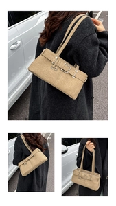Detail shot of vintage beige shoulder bag with decorative belt buckle and metal rings