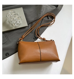 Detail of caramel leather shoulder bag with fine litchi grain and knot strap detail