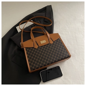 Detail view of vintage Boston bag with brown leather accents and gold twist lock