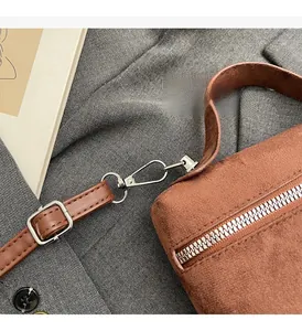 Detail of premium brown suede bag featuring high-quality silver metal hardware and zipper