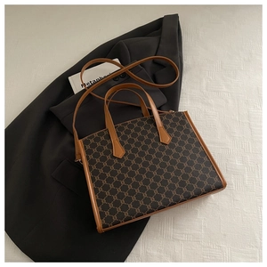 Detail of vintage monogram canvas tote with brown leather trim on black blazer