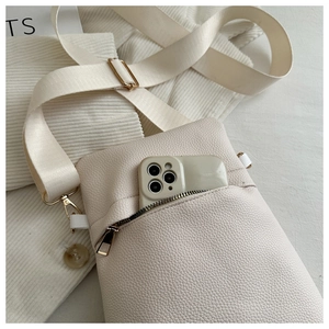 Close-up of cream lychee texture crossbody bag with adjustable wide strap and phone pocket