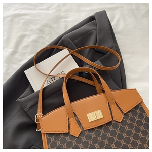 Detail of vintage canvas tote with leather trim and gold twist lock closure on a book
