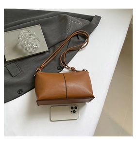Detailed top view of a minimalist caramel leather crossbody bag with stitching details
