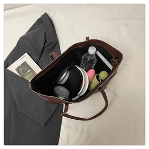 Detailed top view of a large brown tote bag showing its spacious interior and zipper closure