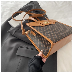 Close-up of retro patterned tote bag with metal turn-lock on a grey suit jacket