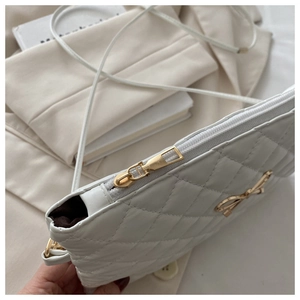 Détail du sac matelassé blanc avec boucle nœud dorée et coutures fines sur cuir souple
