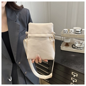 Close-up of cream crossbody bag featuring lychee grain leather and adjustable wide strap