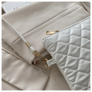 Détail du sac à main matelassé blanc avec ferrures dorées et texture cuir de luxe