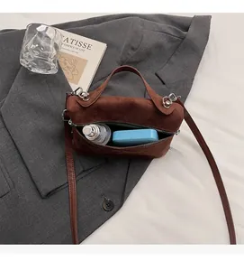 Vue intérieure montrant la grande capacité d'un sac à main en daim marron élégant