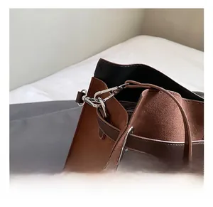 Close-up of durable silver metal hook and premium brown suede strap on tote bag