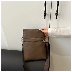 Detail of dark brown lychee pattern leather crossbody phone bag with adjustable strap