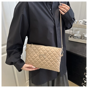 Gros plan du sac beige matelassé avec boucle en métal doré et texture en cuir PU