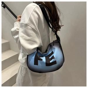 Detail of blue gradient crossbody bag showing FE print and wide nylon shoulder strap