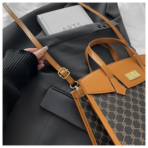 Detail view of vintage brown leather tote with signature pattern and golden lock