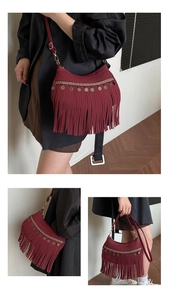 Nahaufnahme der weinroten Hobo-Tasche mit Boho-Fransen und Metallmünzen-Verzierung