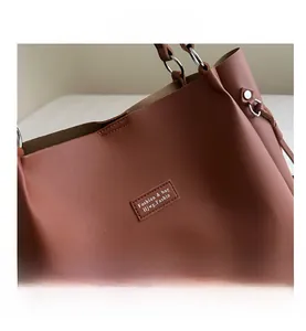 Close-up of caramel leather tote bag with fine stitching and silver metal ring hardware