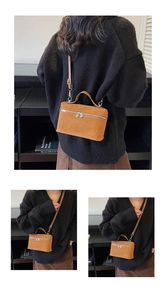 Détail du sac boîte en daim marron avec fermetures éclair cœur argentées et bandoulière
