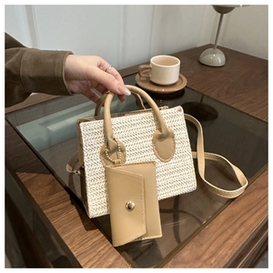 Detail of minimalist straw tote bag featuring detachable pouch and wood-styled background