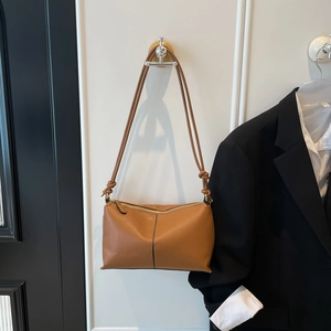 Minimalist brown faux leather shoulder bag with decorative knot and zipper closure