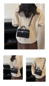 Détail d'un mini sac noir en suédine avec fermetures éclair cœur et bandoulière