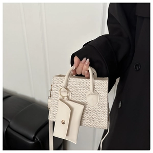 Detail of cream woven handbag with matching mini pouch and circular top handle