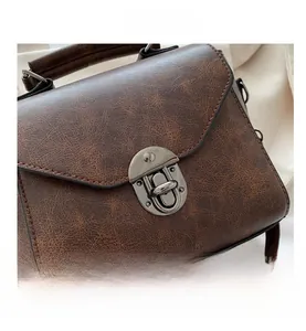 Gros plan d'un sac à main en cuir marron vintage avec un fermoir rotatif en métal chic
