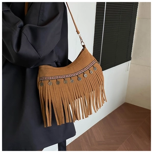 Close-up of brown suede tassel shoulder bag with ethnic woven strap and silver metal charms