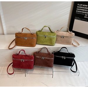 Detail of suede box bags with heart-shaped metal zippers and diverse color options