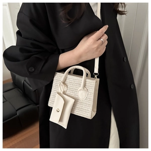 Detail of cream woven straw handbag featuring a herringbone pattern and mini pouch