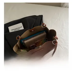 Top-down view of spacious brown tote bag interior holding a tablet and books