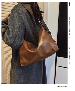 Close-up of brown oversized soft leather hobo bag with adjustable wide shoulder strap