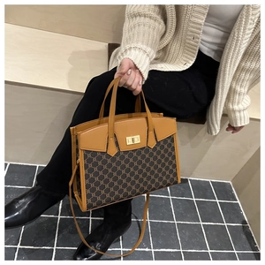 Detailed view of the vintage monogram tote bag with brown leather trim and golden lock